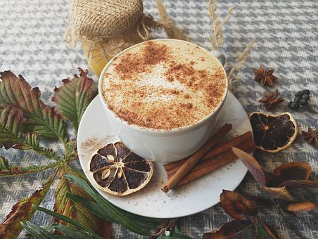 Cinnamon on coffee with autumn table decorations