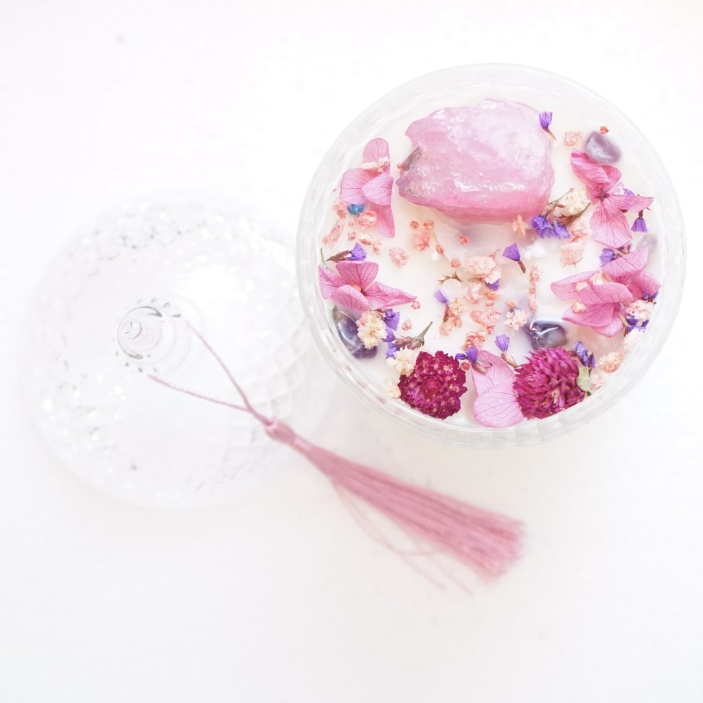 Candle with flowers and crystals in