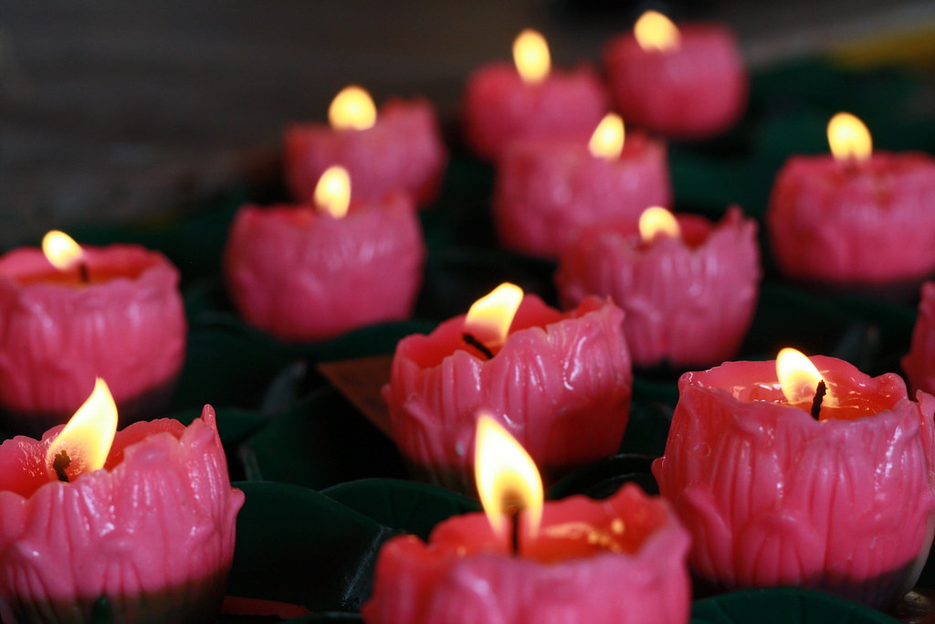 Lots of pink candles that are lit