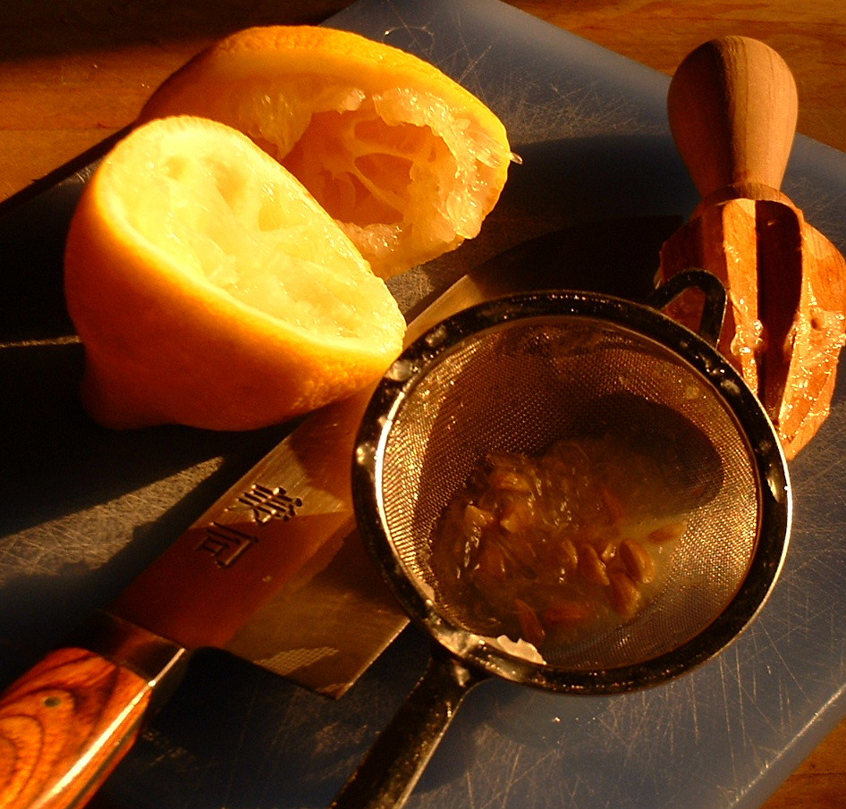 Lemon being squeezed and sieved for use