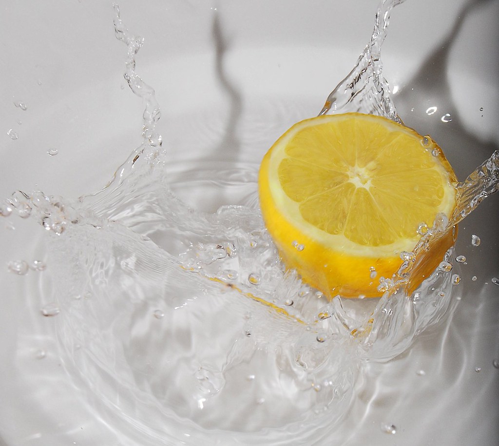 A half of lemon being dropped into water and making a splash! 